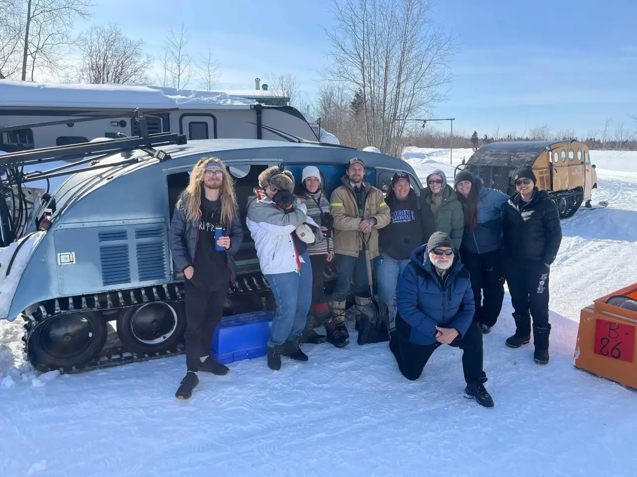 AMT students with a snow vehicle in the snow